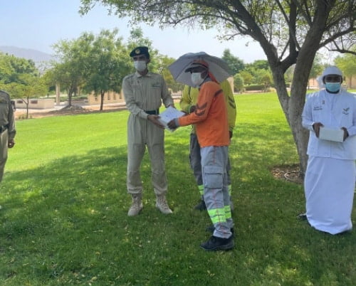 شرطة دبي توزع قبعات مظلة ووجبات على العمال - الأخبار